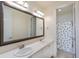 Bathroom with a double sink vanity, large mirror, and tiled shower at 11880 W 38Th Pl, Wheat Ridge, CO 80033