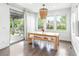 Bright dining room with natural wood table, bench seating, modern lighting, and sliding glass doors to the backyard at 11880 W 38Th Pl, Wheat Ridge, CO 80033