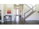 Bright entryway with dark hardwood floors, white walls, and a staircase with white railings at 11880 W 38Th Pl, Wheat Ridge, CO 80033