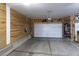 Spacious garage featuring wood-paneled walls, a concrete floor, and an automatic garage door with a modern design at 11880 W 38Th Pl, Wheat Ridge, CO 80033