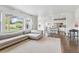 Open-concept living room with a view into the kitchen, featuring hardwood floors and natural light at 11880 W 38Th Pl, Wheat Ridge, CO 80033