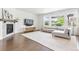 Bright living room with a fireplace, large windows, hardwood floors, and a comfortable sectional sofa at 11880 W 38Th Pl, Wheat Ridge, CO 80033