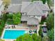 Aerial view of a private backyard oasis featuring a pool, patio, hot tub, and lush landscaping at 9470 S Silent Hills Dr, Lone Tree, CO 80124