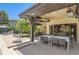 Covered outdoor dining and lounging area next to the pool, with a modern grill and a relaxing swing chair at 9470 S Silent Hills Dr, Lone Tree, CO 80124