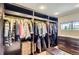 Spacious walk-in closet features custom storage solutions, bench seating and natural light at 9470 S Silent Hills Dr, Lone Tree, CO 80124