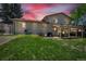 Backyard at dusk features a lush lawn, patio, and covered dining area at 16941 E Eastman Pl, Aurora, CO 80013