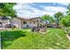 Backyard featuring a stone-laid seating area, lush green lawn, and a view of the home's exterior at 16941 E Eastman Pl, Aurora, CO 80013