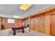 Basement recreational area with a pool table, wood paneled walls, and a glimpse of an adjacent room at 16941 E Eastman Pl, Aurora, CO 80013