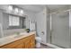 Bathroom featuring a glass shower, wood vanity, mirror, and modern fixtures at 16941 E Eastman Pl, Aurora, CO 80013