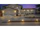 Charming home illuminated at dusk features manicured landscaping, a garage, and brick accents at 16941 E Eastman Pl, Aurora, CO 80013