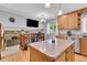 Bright, open kitchen with island, wooden cabinets, and adjacent living space at 16941 E Eastman Pl, Aurora, CO 80013
