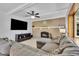 Spacious living room with brick fireplace, large TV, ceiling fan and large sectional sofa at 16941 E Eastman Pl, Aurora, CO 80013