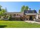 Spacious backyard with a wooden deck, patio, and lush green lawn at 11035 W 26Th Pl, Lakewood, CO 80215