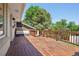 Large deck with wooden railing, seating area, and mature trees at 11035 W 26Th Pl, Lakewood, CO 80215