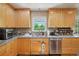 Nicely appointed kitchen featuring stainless steel appliances, tiled backsplash, and light wood cabinetry at 11035 W 26Th Pl, Lakewood, CO 80215