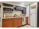 Kitchenette area featuring stainless steel appliances, wood cabinets and tile flooring at 11035 W 26Th Pl, Lakewood, CO 80215