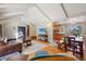 Open living area with hardwood floors, beamed ceiling, and a smooth transition into kitchen and staircase at 11035 W 26Th Pl, Lakewood, CO 80215