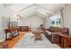 Bright living room with vaulted ceilings, hardwood floors, and a comfortable leather sofa at 11035 W 26Th Pl, Lakewood, CO 80215