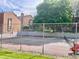 Outdoor tennis court surrounded by a chain link fence, trees and buildings on a bright day at 4281 S Salida Way # 5, Aurora, CO 80013