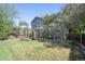 Landscaped backyard with a wooden fence, large grass area, and mature trees at 2935 Bow Line Pl, Longmont, CO 80503