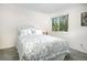 Comfortable bedroom with a floral comforter, carpet flooring, and a bright window at 2935 Bow Line Pl, Longmont, CO 80503