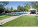 Inviting community pool with lounge chairs, lush green grass and a pool house at 2935 Bow Line Pl, Longmont, CO 80503