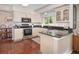 Well-lit kitchen featuring granite countertops, stainless steel appliances, and hardwood floors at 2935 Bow Line Pl, Longmont, CO 80503