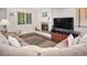 Cozy living room featuring a fireplace, large sofa, and hardwood floors at 2935 Bow Line Pl, Longmont, CO 80503