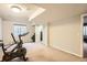 Spacious carpeted basement with an exercise bike and access to other rooms and storage at 9306 W 13Th Pl, Lakewood, CO 80215