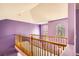 Hallway with lavender walls and wooden railing, and arched windows allowing natural light at 9306 W 13Th Pl, Lakewood, CO 80215