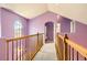 Hallway with wooden railing, lavender walls, arched windows and doorways providing natural light at 9306 W 13Th Pl, Lakewood, CO 80215