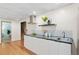 Basement kitchenette with white cabinets, dark countertop, and subway tile backsplash at 4070 W Dartmouth Ave, Denver, CO 80236