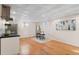 Basement kitchenette with white cabinets, modern appliances, and wood flooring at 4070 W Dartmouth Ave, Denver, CO 80236