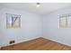 Well-lit bedroom featuring light walls, wood floors, and dual windows at 4070 W Dartmouth Ave, Denver, CO 80236