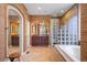 Primary bathroom featuring dual vanities, soaking tub, walk-in shower and lots of natural light at 6047 Vacquero Cir, Castle Pines, CO 80108