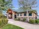 Exterior of a clubhouse building with stone pillars, well-maintained landscaping, and a sidewalk at 6047 Vacquero Cir, Castle Pines, CO 80108