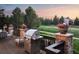 Outdoor deck featuring a stainless steel grill, patio furniture, and decorative flower planters on stone pillars at 6047 Vacquero Cir, Castle Pines, CO 80108