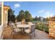 Wooden outdoor deck with a round table and four chairs overlooking the manicured green lawns at 6047 Vacquero Cir, Castle Pines, CO 80108