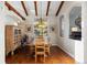 Dining room with hardwood floors, exposed beams, adjacent to an arched doorway at 6047 Vacquero Cir, Castle Pines, CO 80108