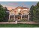 Elegant multi-story house with expansive windows and fenced yard at 6047 Vacquero Cir, Castle Pines, CO 80108