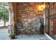 Cozy front porch featuring stone accents, seating, and a decorative light fixture adding character at 6047 Vacquero Cir, Castle Pines, CO 80108