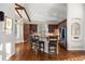 Gourmet kitchen with stainless appliances, wooden cabinets, breakfast bar with chairs and hardwood floors at 6047 Vacquero Cir, Castle Pines, CO 80108