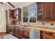 Kitchen with wooden cabinets, a stone countertop, stainless steel appliances, and a window at 6047 Vacquero Cir, Castle Pines, CO 80108