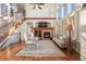 Bright living room with fireplace, hardwood floors, large windows, and staircase at 6047 Vacquero Cir, Castle Pines, CO 80108
