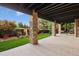 Covered patio with stone pillars overlooking a grass lawn and garden, including plants and stones at 6047 Vacquero Cir, Castle Pines, CO 80108