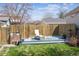 A serene backyard setting including privacy fence, small deck, and mature trees at 1958 S Pearl St, Denver, CO 80210