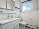 Clean bathroom featuring a modern sink, toilet, and wood paneling at 1958 S Pearl St, Denver, CO 80210