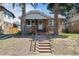 Charming brick bungalow with covered porch and landscaped front yard welcomes you home at 1958 S Pearl St, Denver, CO 80210