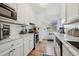 Well-lit kitchen with stainless steel appliances, white cabinets, and stone countertops at 1958 S Pearl St, Denver, CO 80210