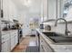 Well-lit kitchen with stainless steel appliances, white cabinets, and stone countertops at 1958 S Pearl St, Denver, CO 80210